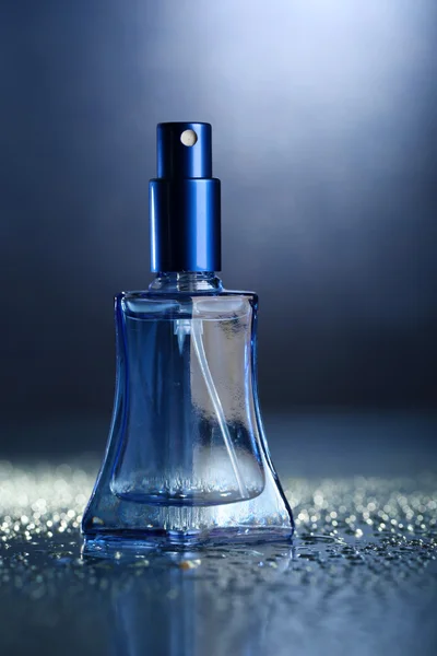 Perfume de mujer en hermosa botella sobre fondo azul —  Fotos de Stock