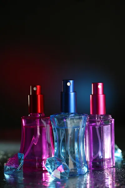 Γυναικών άρωμα σε όμορφο φιάλες σε σκούρο φόντο με χρώμα φως — Φωτογραφία Αρχείου