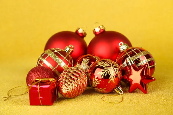 Weihnachtskugeln und kleines Geschenk auf gelbem Hintergrund — Stockfoto
