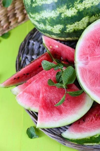 Ripe watermelons on wicker tray on wooden table — Stock Photo, Image