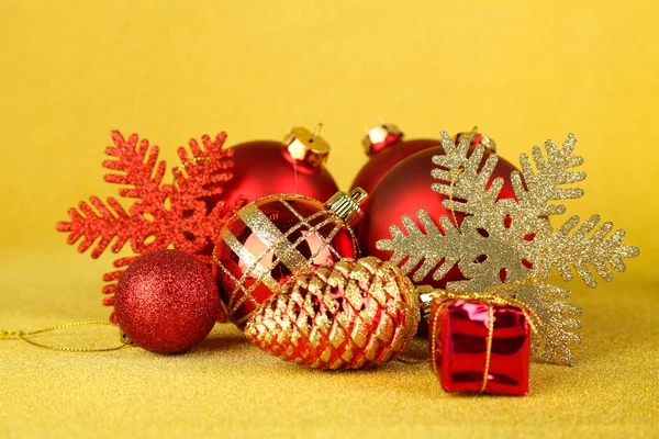 Christmas balls and small gift on yellow background — Stock Photo, Image