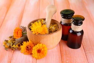 ilaç şişeleri ve ahşap zemin üzerine calendula çiçekler