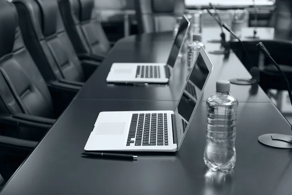 Sala de conferências vazia com laptops na mesa em tons de cinza — Fotografia de Stock