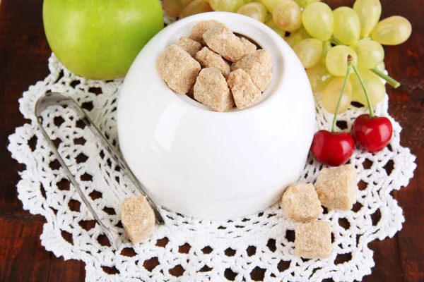 Unrefined sugar in white sugar bowl on wooden background — Stock Photo, Image