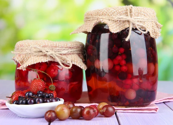 Marmellata di bacche fatta in casa su tavolo di legno su sfondo luminoso — Foto Stock