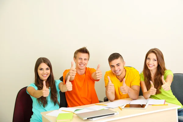 Grupo de jóvenes estudiantes sentados en la habitación — Foto de Stock