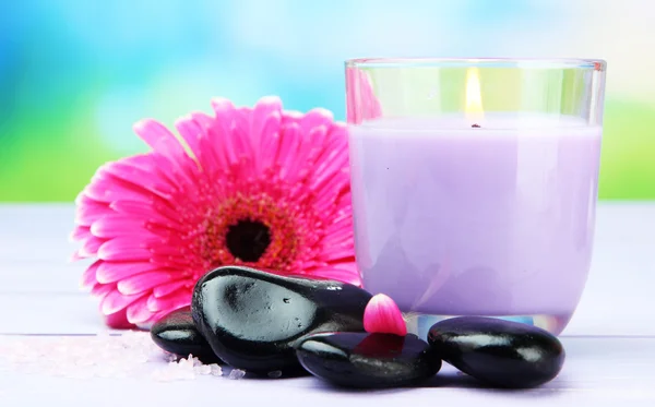 Wellness-Steine, schöne Gerbera und Kerze auf Holztisch — Stockfoto