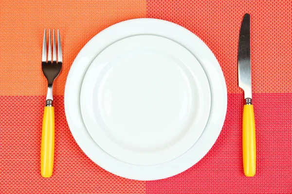 Knife, color plate and fork, on color background — Stock Photo, Image