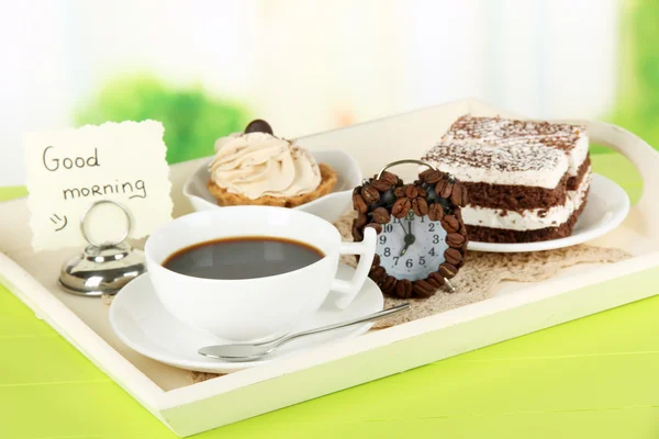 Cup of tea with cakes on wooden tray on table in room — Stock Photo, Image