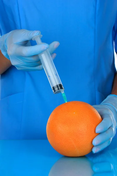 Ученые делают инъекции в свежий грейпфрут в лаборатории — стоковое фото