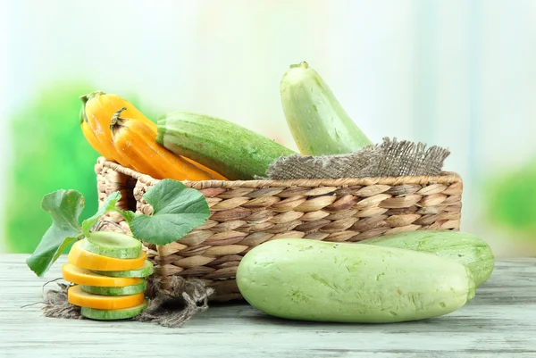 Skivad och hela råa zucchini i wicker spjällådan, utomhus — Stockfoto