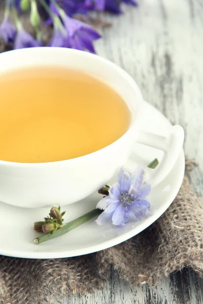 Cup of tea with chicory, on wooden background — Stock Photo, Image