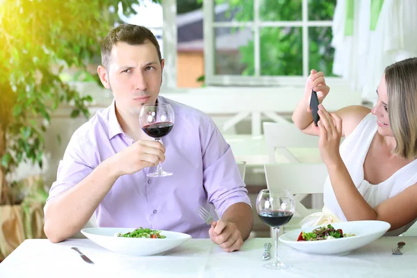 Casal jovem tirando foto com telefone celular no restaurante — Fotografia de Stock