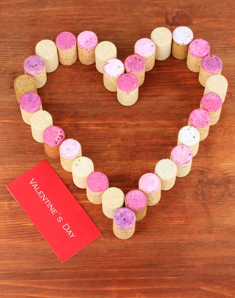 Wine corks laid out in form of heart on wooden table close-up — Stock Photo, Image