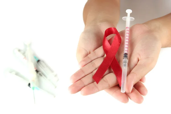 エイズのリボンと白で隔離される手で注射器 — ストック写真