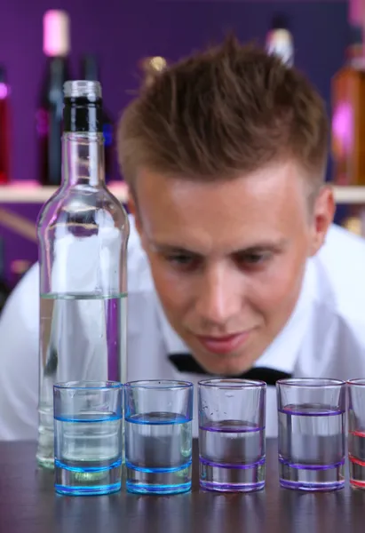 Barkeeper schüttet Wodka in Gläser — Stockfoto