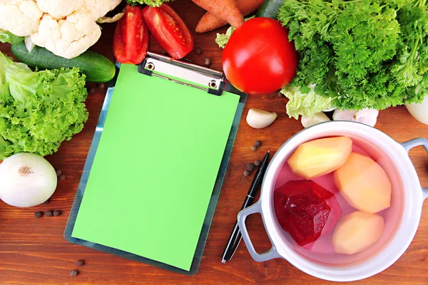 Verduras frescas y especias y papel para notas, sobre fondo de madera — Foto de Stock