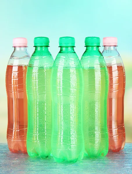 Assortment of bottles with tasty drinks, on bright background — Stock Photo, Image