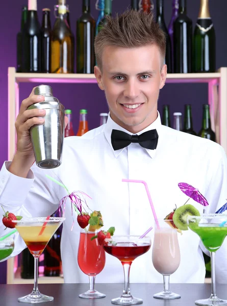 Portrait of handsome barman with different cocktails cocktail, at bar — Stock Photo, Image