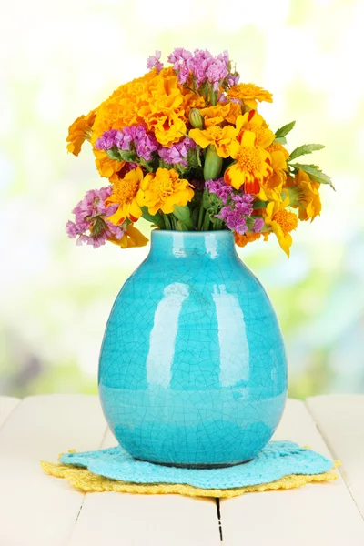 マリーゴールドの花の自然な背景に木製のテーブルの上に花瓶の花束 — ストック写真