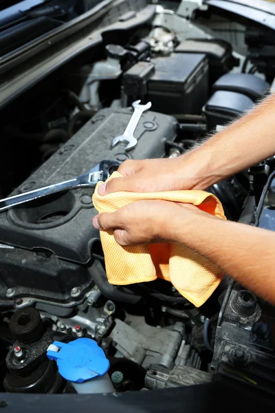 Mecânico do motor limpando suas mãos gordurosas após a manutenção do carro — Fotografia de Stock