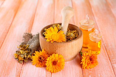 ilaç şişeleri ve ahşap zemin üzerine calendula çiçekler