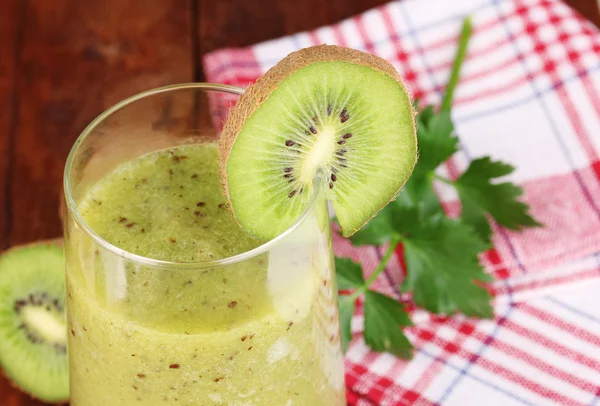 Verre de jus de kiwi frais sur table en bois — Photo