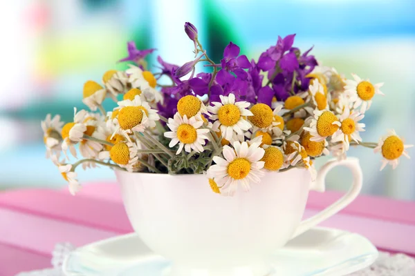Boeket van kamille bloemen in cup, op lichte achtergrond — Stockfoto