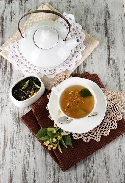 Tasse de thé avec tilleul sur serviettes sur table en bois — Photo