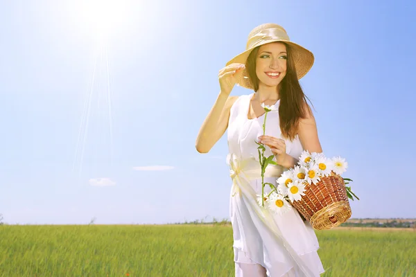 Porträtt av vacker ung kvinna med blommor i fältet — Stockfoto