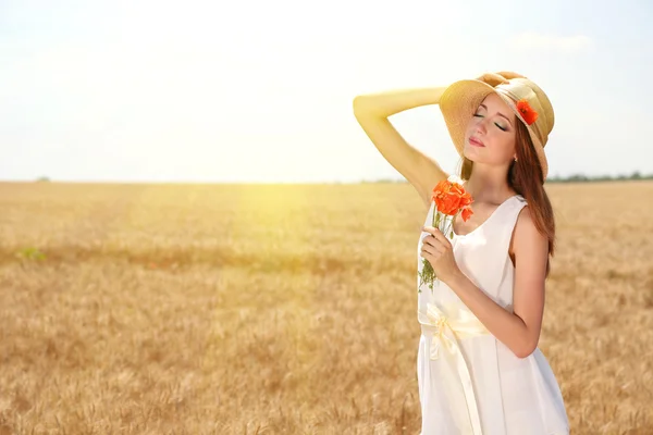 Portret van mooie jonge vrouw met papavers op het gebied — Stockfoto