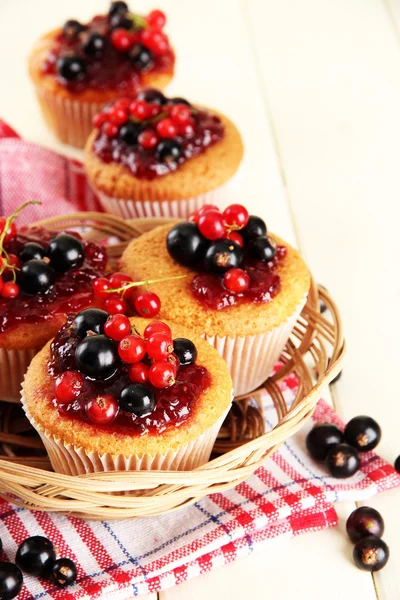 Muffins saborosos com bagas na mesa de madeira branca — Fotografia de Stock