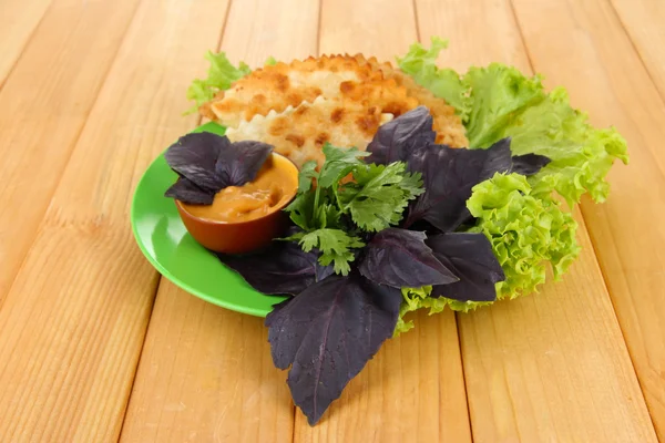 Chèques savoureux avec des herbes fraîches sur l'assiette, sur fond en bois — Photo