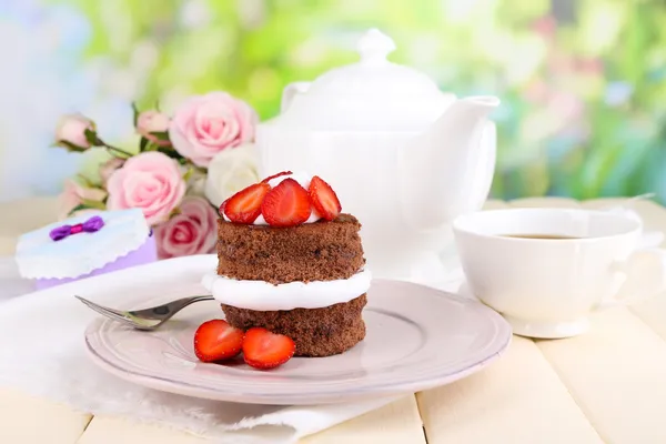 Schokoladenkuchen mit Erdbeere auf Holztisch vor natürlichem Hintergrund — Stockfoto