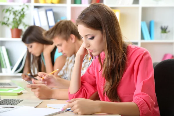 Group of young students sitting at the library — Stock Photo, Image
