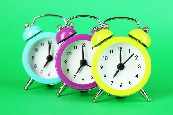 Colorful alarm clock on green background — Stock Photo, Image