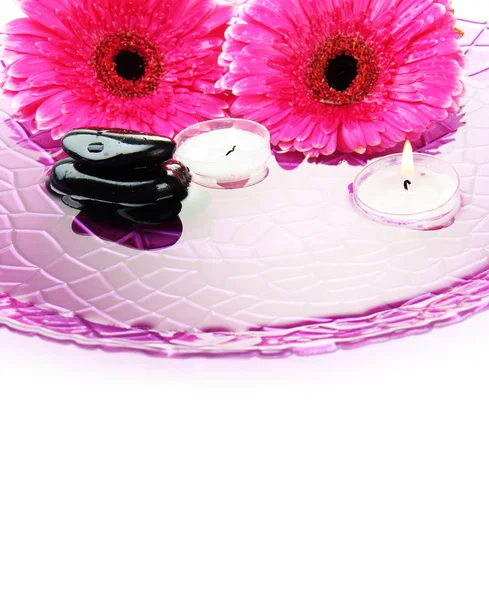 Pietre termali, fiori di gerbera e candele sull'acqua, isolate sul bianco — Foto Stock