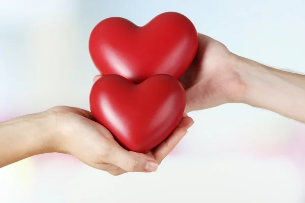 Hearts in hands on light background — Stock Photo, Image