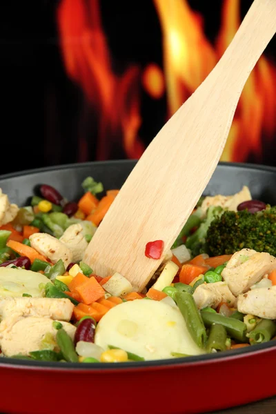 Запеканка с овощами и мясом на сковороде, на огненном фоне — стоковое фото