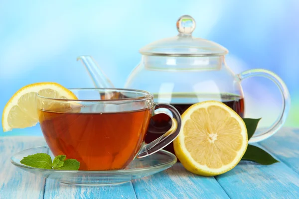 Taza de té con limón sobre la mesa sobre fondo azul — Foto de Stock
