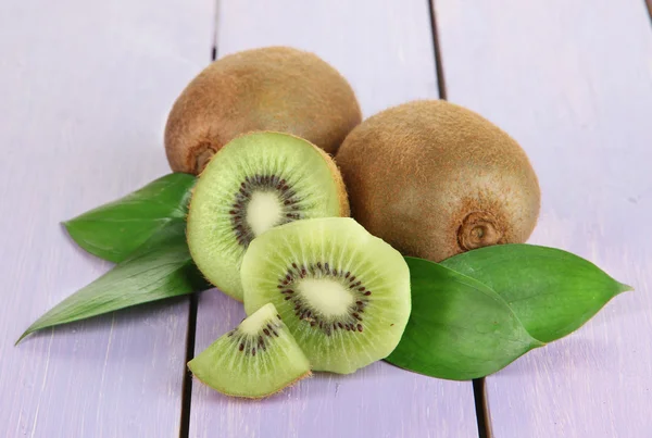 Ripe kiwi on purple wooden table close-up — Stock Photo, Image