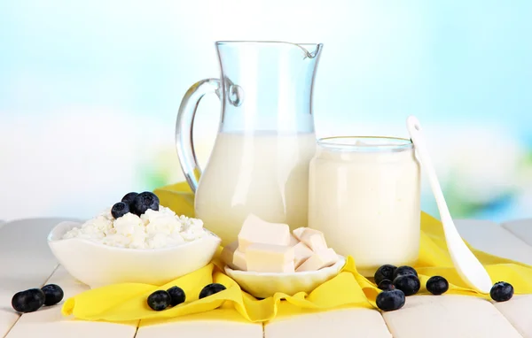 Färska mjölkprodukter med blåbär på träbord på naturliga bakgrund — Stockfoto