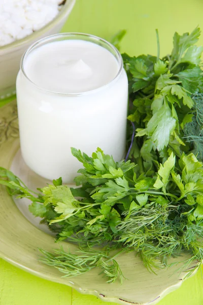 Doğal zemin üzerine ahşap masa üzerinde yeşillikleri ile taze yoğurt — Stok fotoğraf