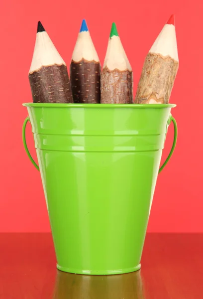 Barevný kbelík s barevné tužky na barvu pozadí — Stock fotografie