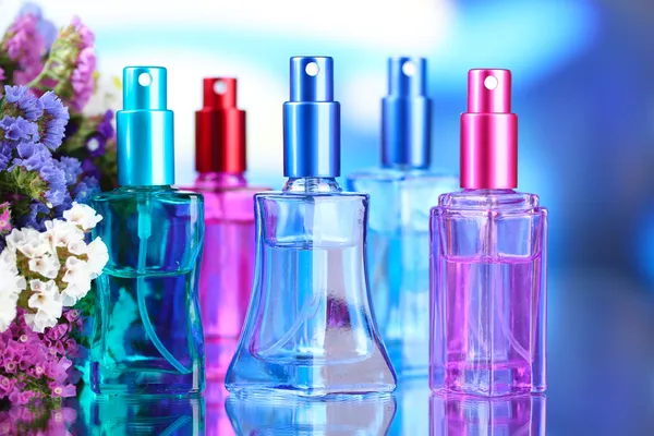 Vrouwen parfum in mooie flessen en bloemen — Stockfoto