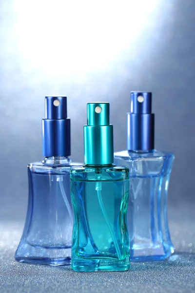 Perfume de las mujeres en hermosas botellas sobre fondo brillante — Foto de Stock