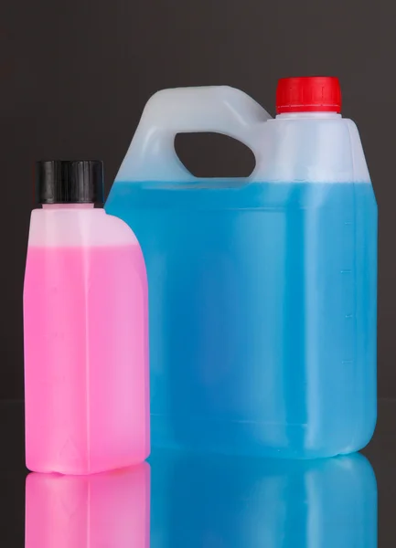 Blue and pink liquids for car in canisters on black background — Stock Photo, Image