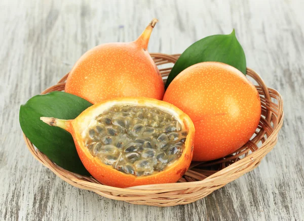 Passion fruits in wicker basket on table close-up — Stock Photo, Image