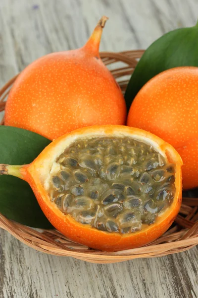 Passion fruits in wicker basket on table close-up — Stock Photo, Image