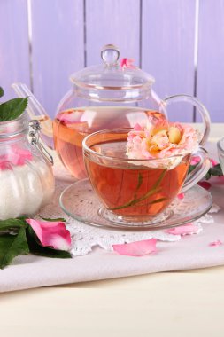 Kettle ve çay gülü peçete ahşap zemin üzerinde gelen